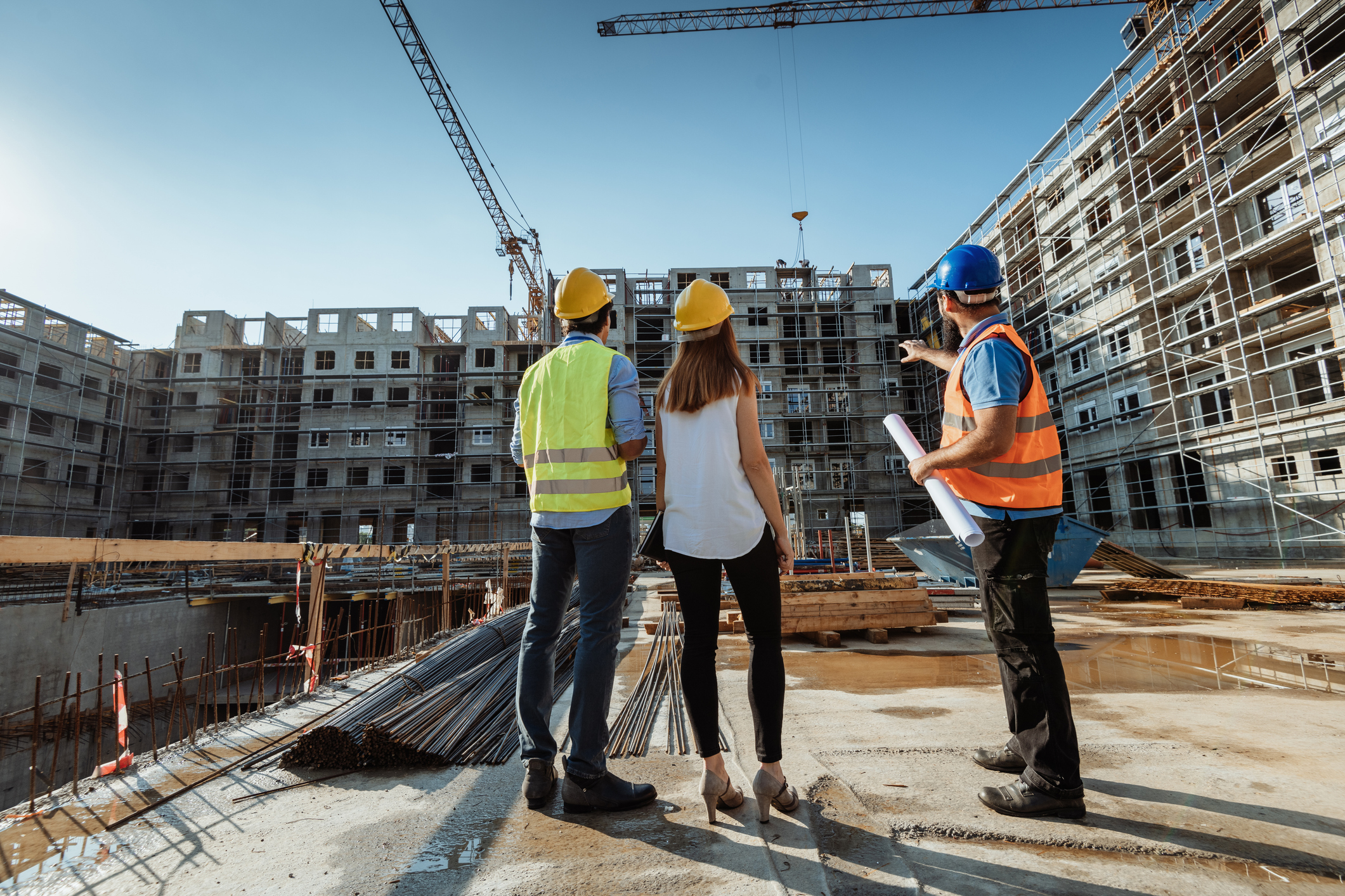Construction workers discussing building plans on site