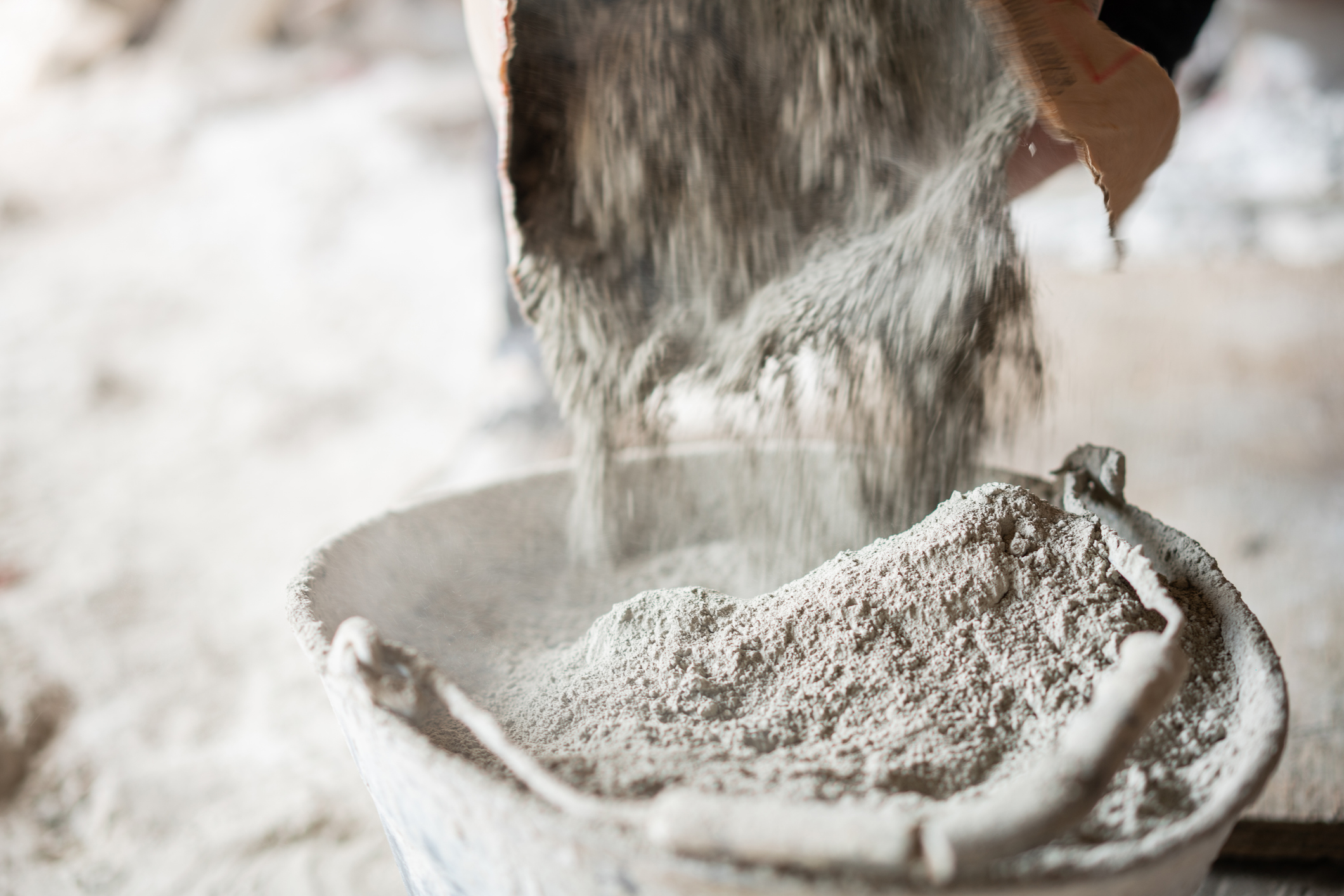 Pouring cement powder into a bucket