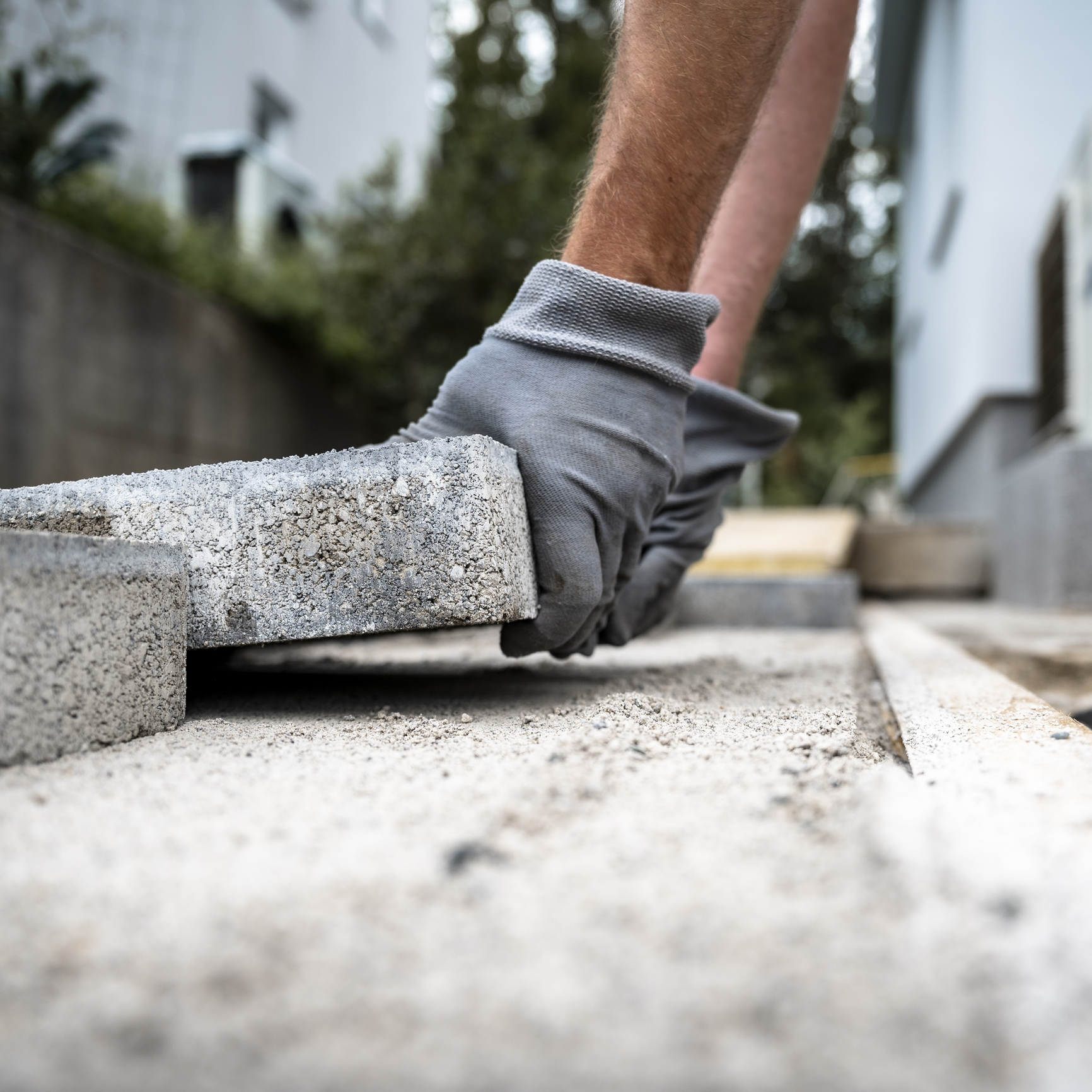 Construction worker installing paving stone
