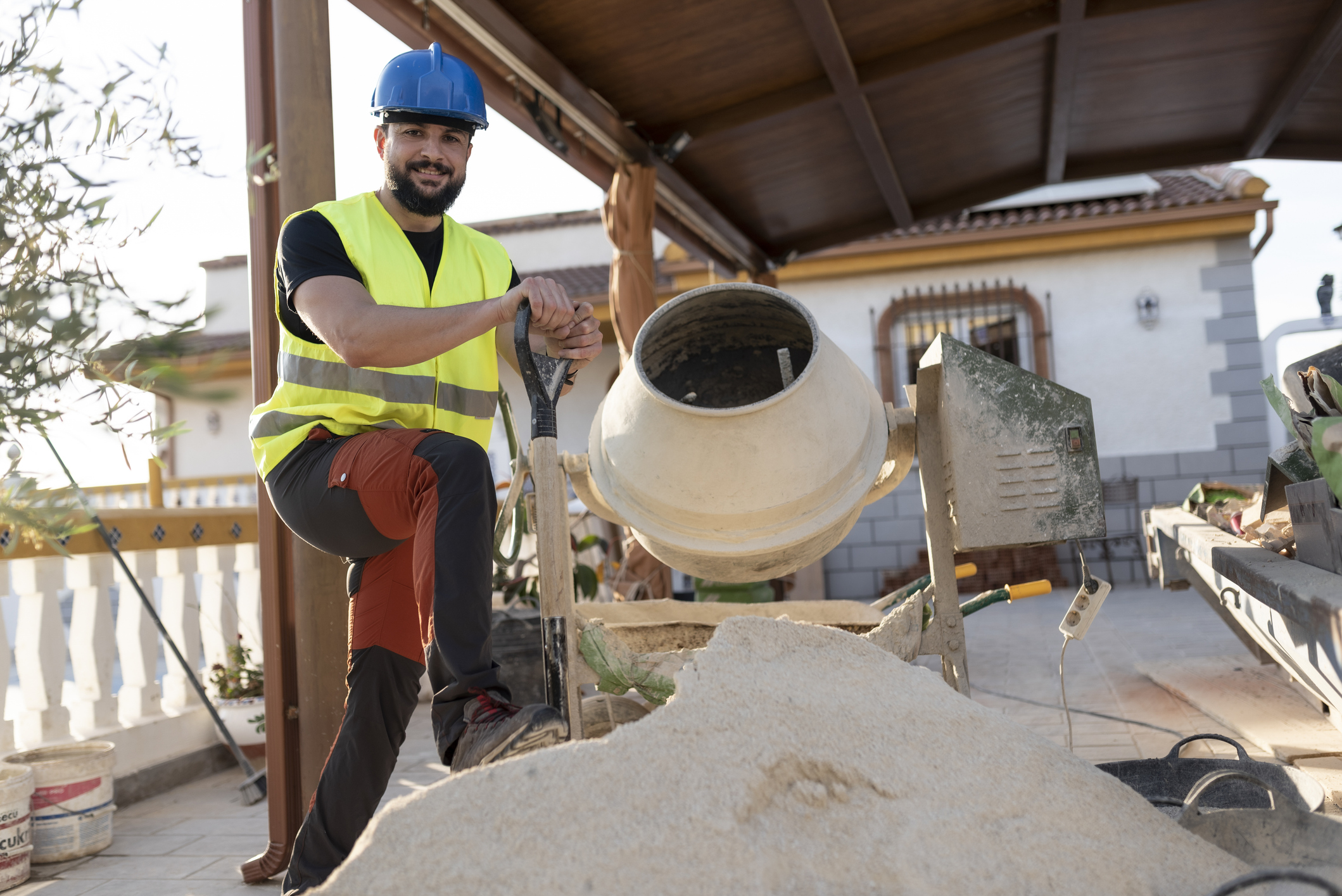 Man operating cement mixer at construction site.
