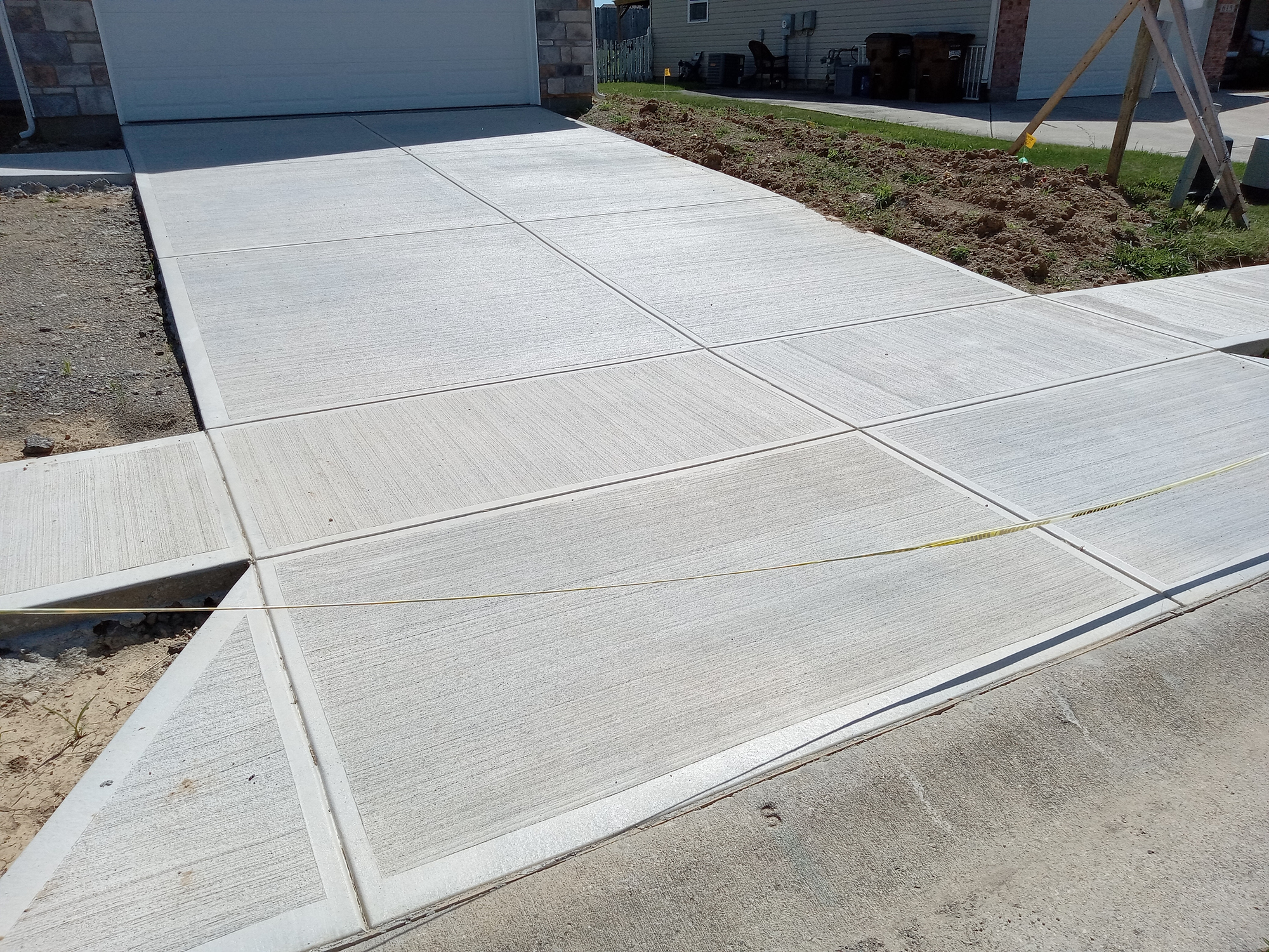 Smooth concrete driveway leading to garage entrance.
