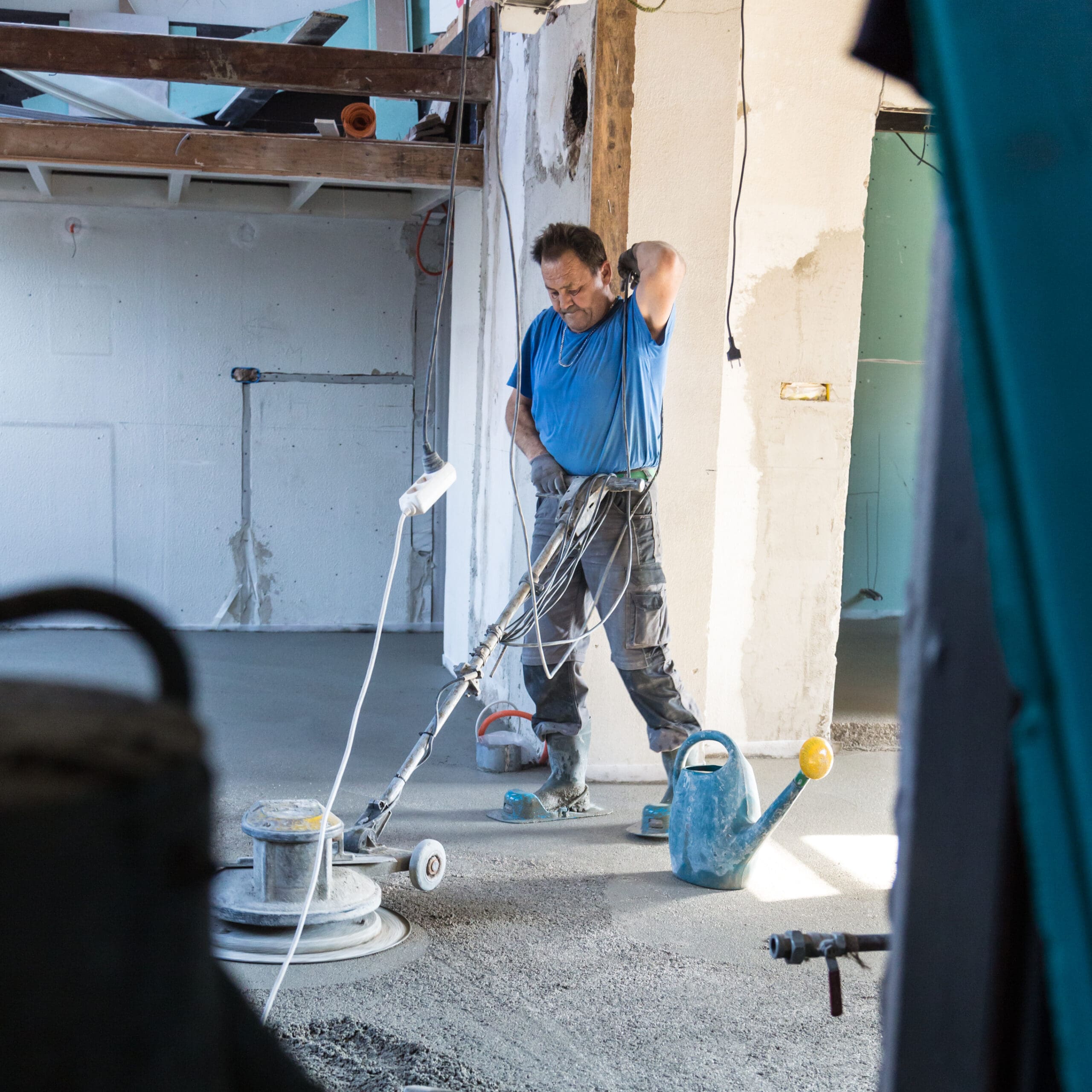Man operating floor grinder in building site