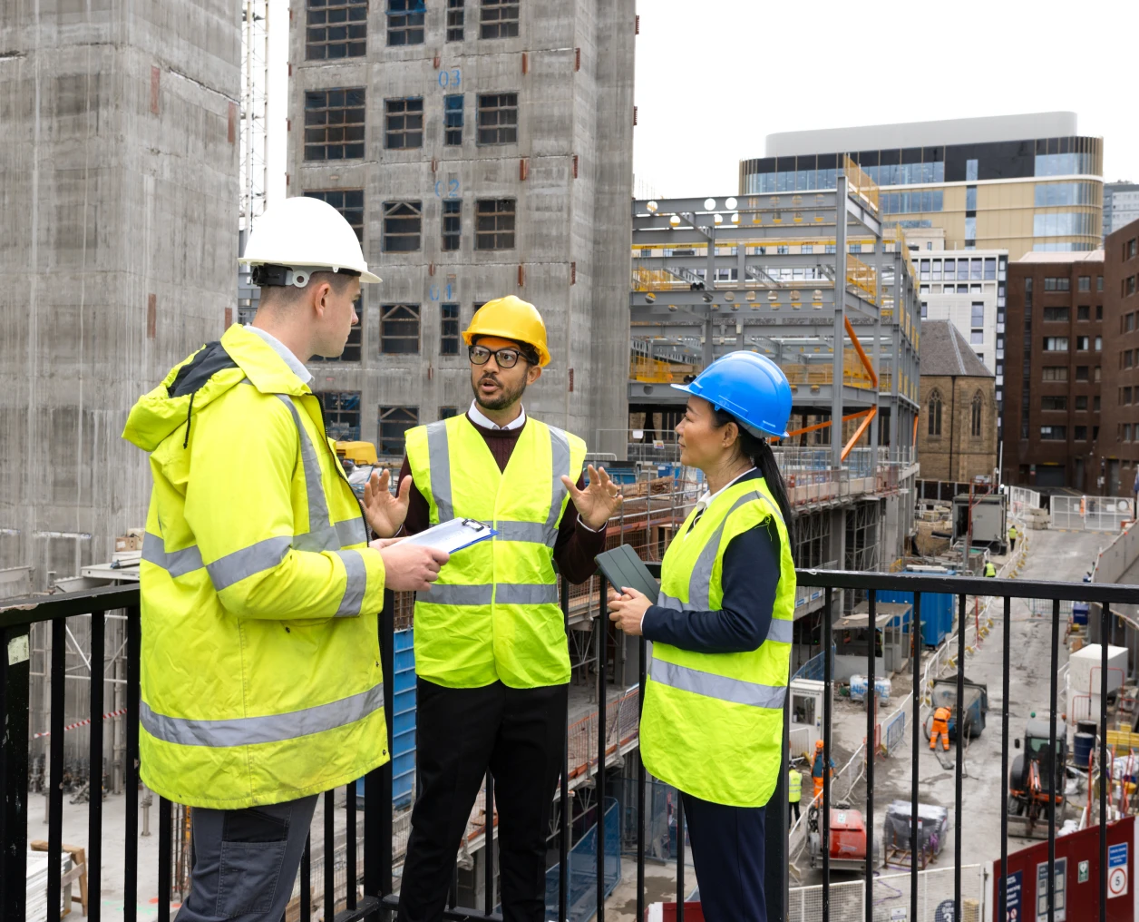 Construction workers in safety gear discussing plans