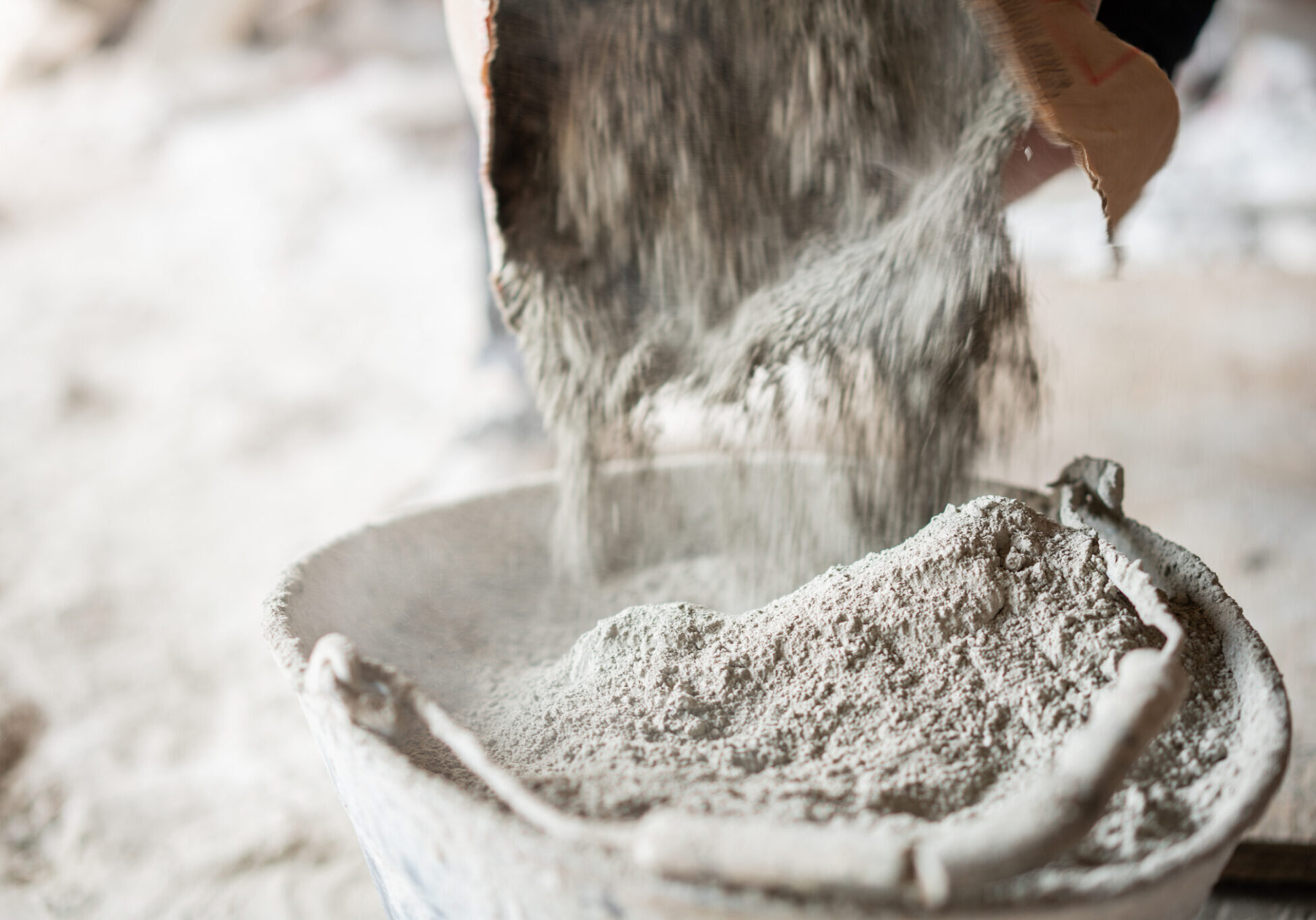 Pouring cement powder into a bucket