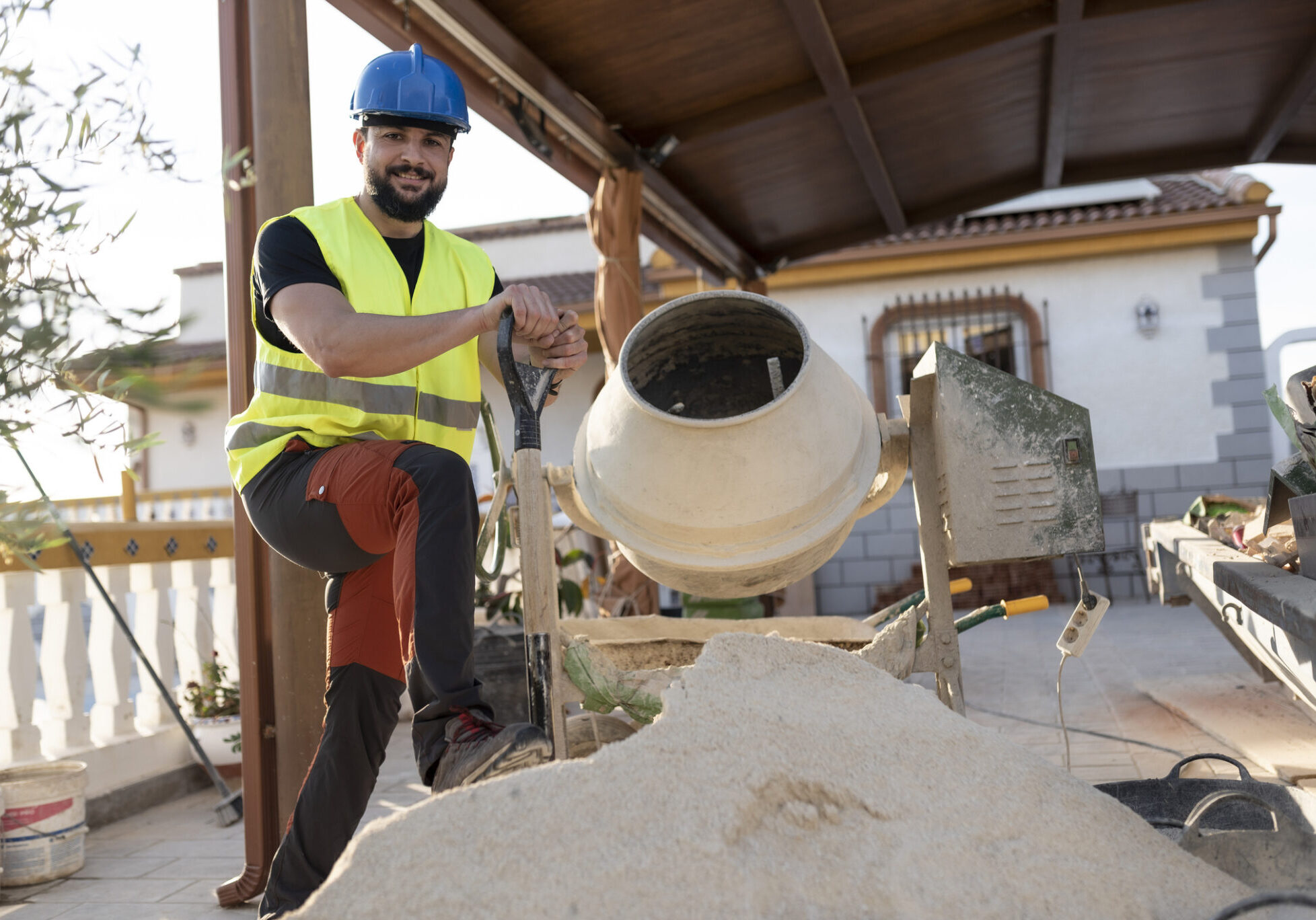 Man operating cement mixer at construction site.