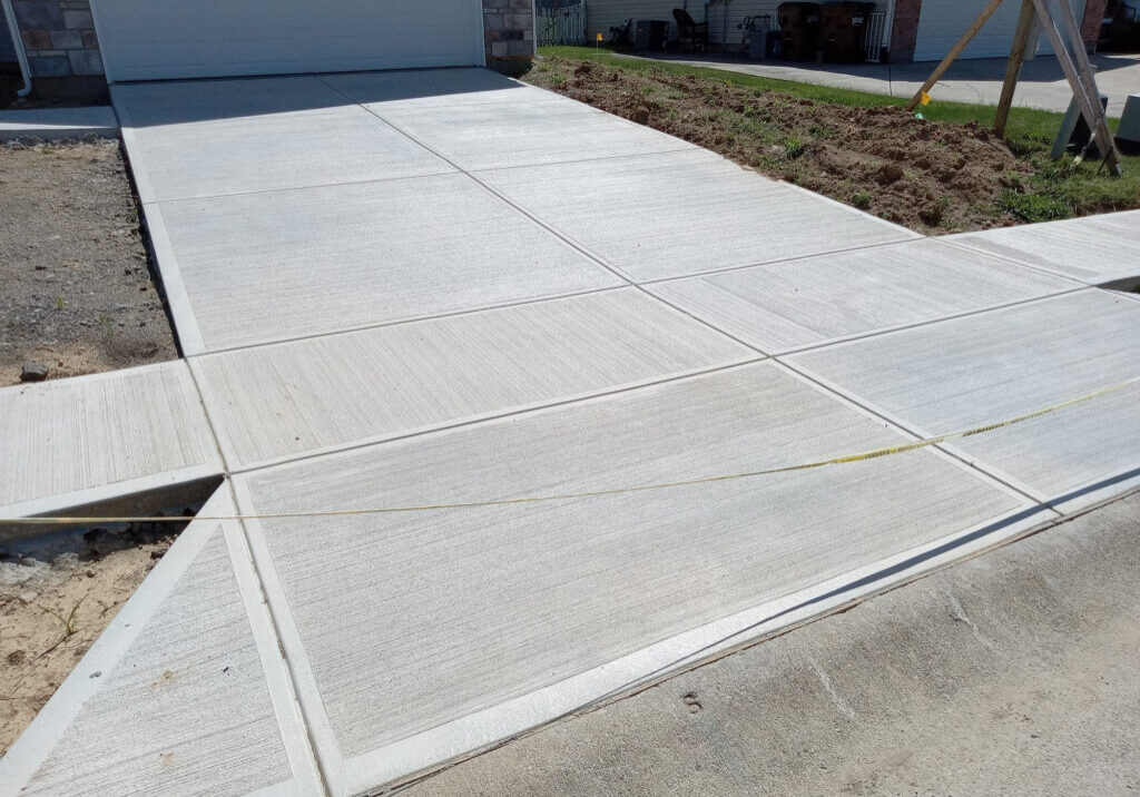 Smooth concrete driveway leading to garage entrance.