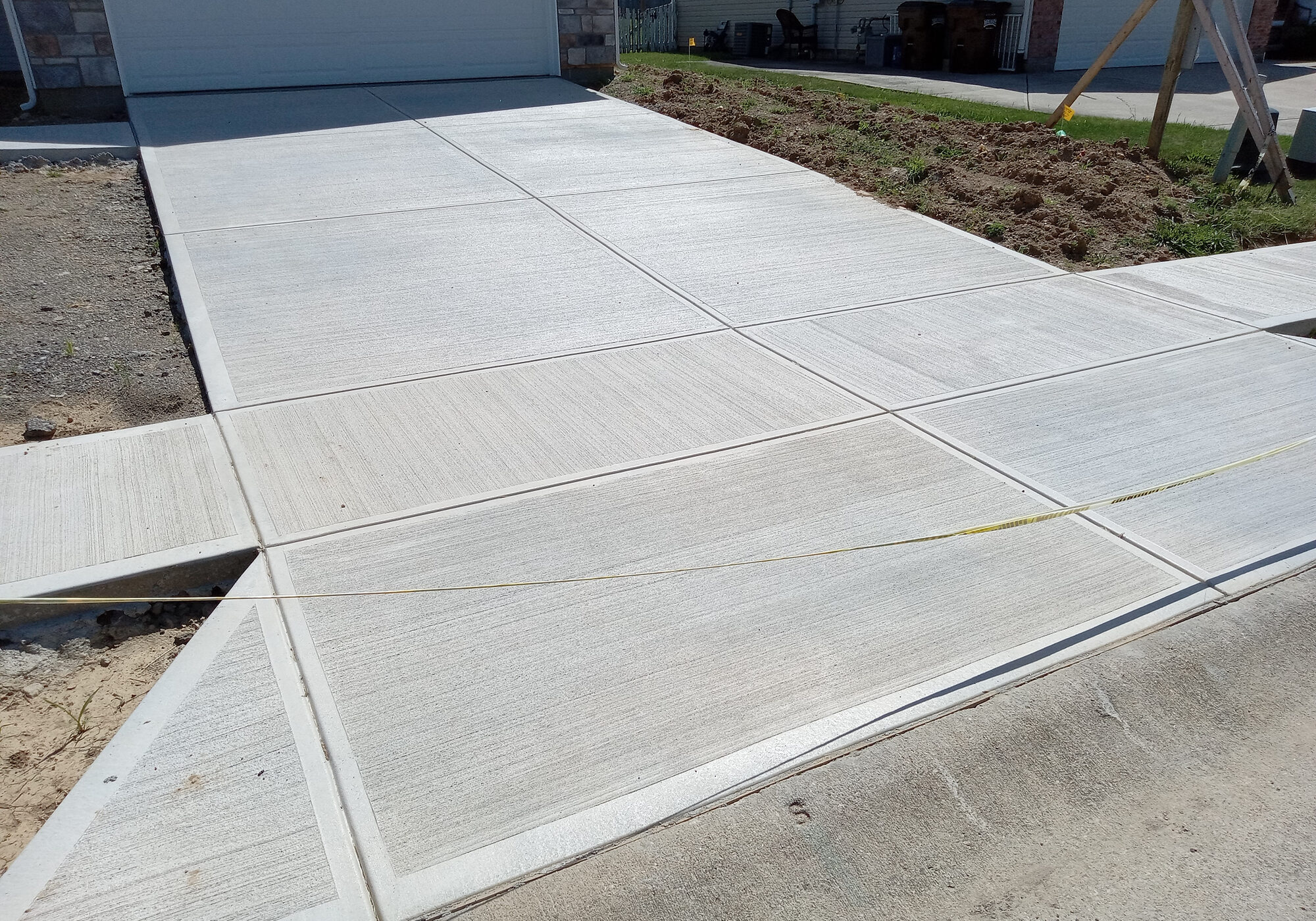 Smooth concrete driveway leading to garage entrance.
