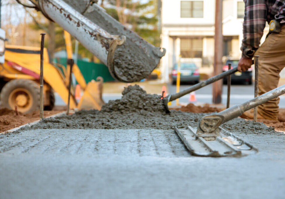 Concrete pouring process in urban area during daylight for new sidewalk installation