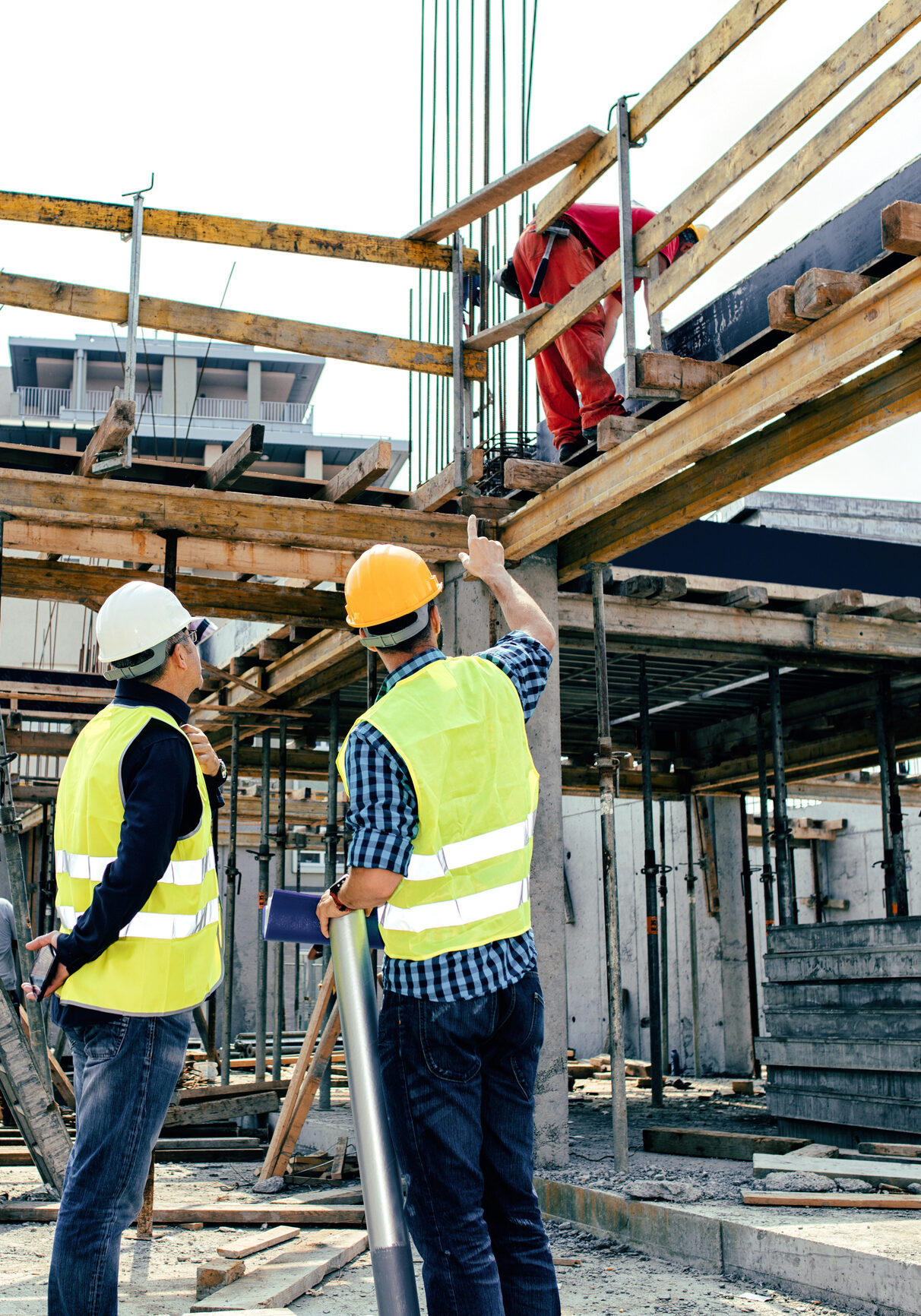 Construction workers inspecting building framework