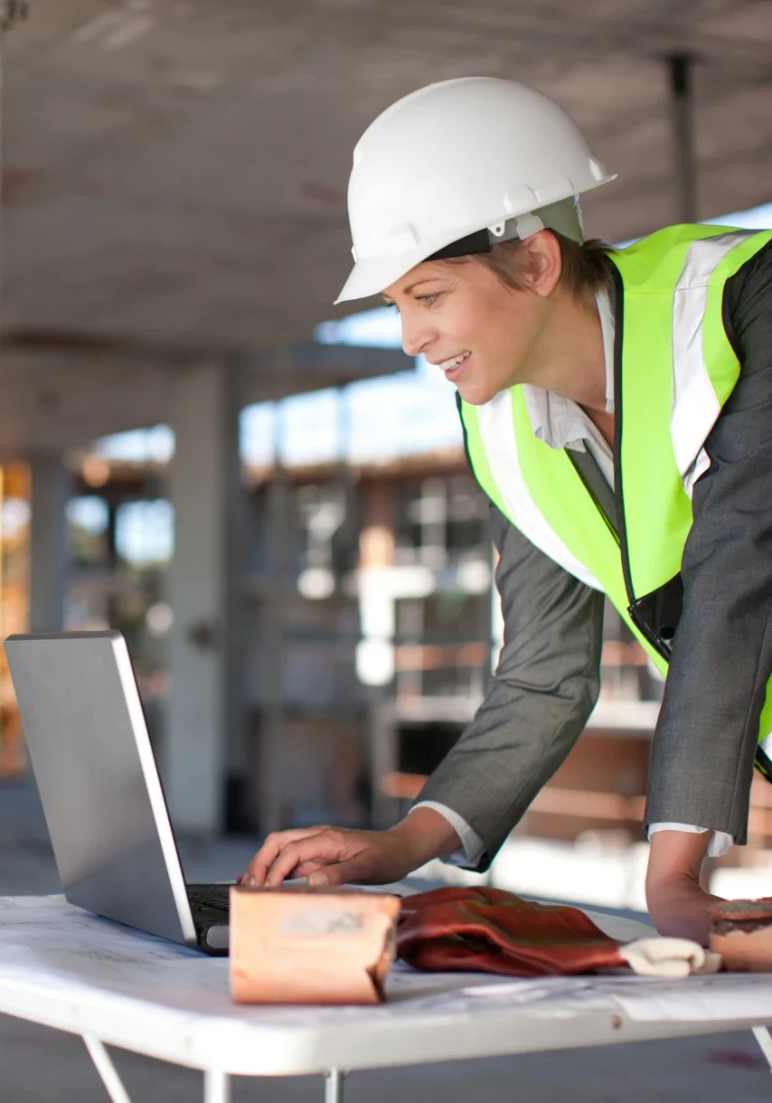 Construction worker using laptop on site